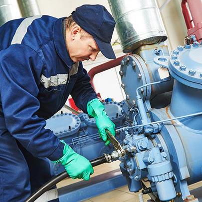 Person working on a valve on a pressurized pipeline