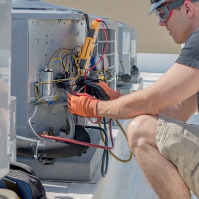 person working on a rooftop heating unit