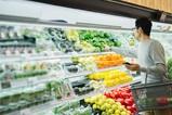 man in grocery store grabs cold fruit