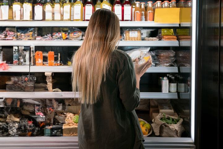 woman shopping in a refrigerated isle