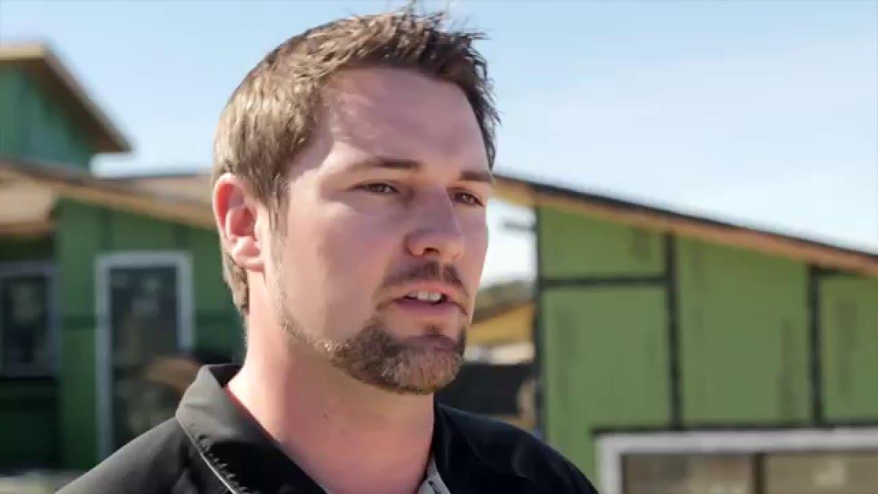 Man in front of unfinished home